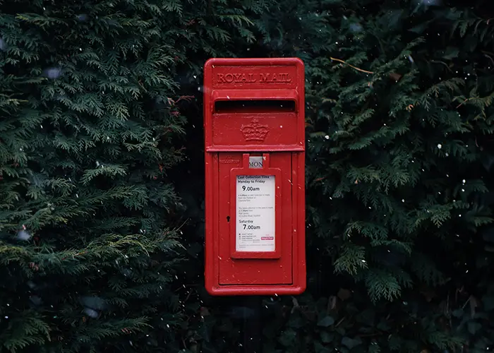 a small postal box in a hedge